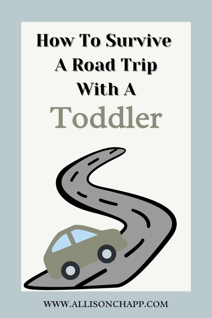 A rectangle graphic with blue on all four sides with a cream rectangle right in the middle with the wording "How to Survive a Road Trip with a Toddler" written in black with the word "Toddler" written in green. The wording is centered at the top of the cream rectangle. Starting at the middle to the bottom of the cream rectangle is a gray road with black outline and black road marks with a Green car driving on it.